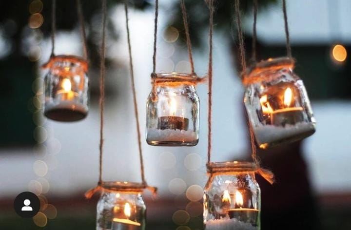 Faroles de vidrio colgantes con velas en un evento