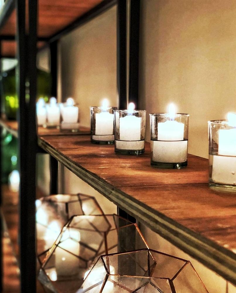 Velas votivas sobre estantería en un salón de eventos